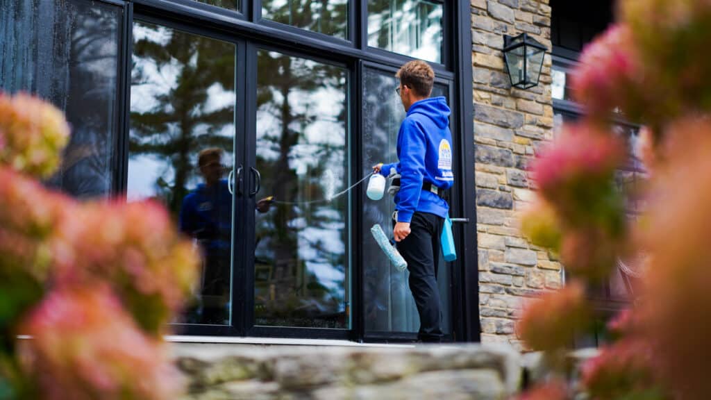 Professional window cleaning services at a residential property in MacTier Ontario overlooking the wooded landscape