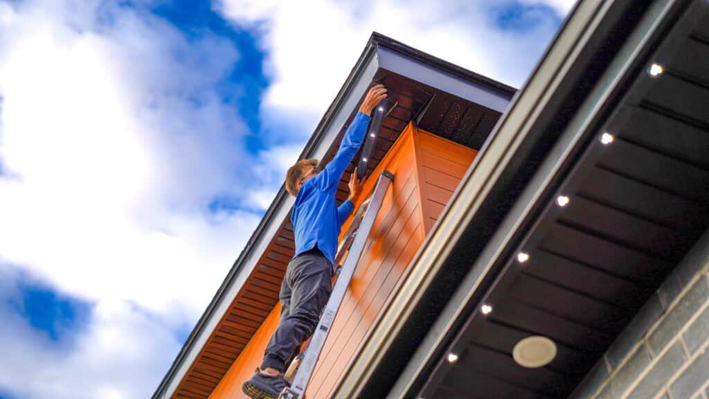 A split-screen or montage showing a Clear View Cleaning technician washing a residential home's windows next to a team performing soft washing on a commercial building storefront.