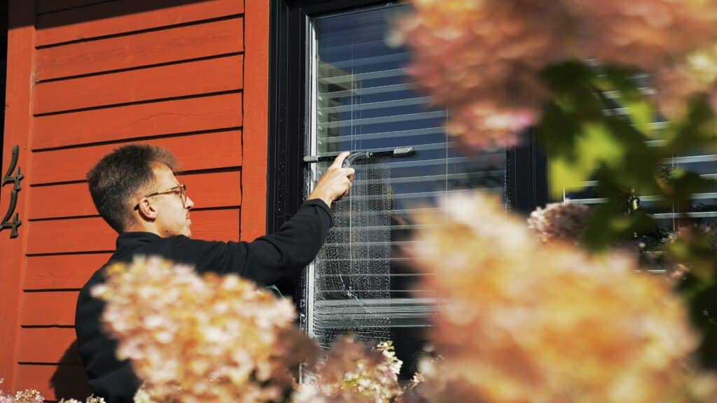 A Clear View Cleaning professional neatly packing equipment and conducting a final review of the window cleaning results with a satisfied homeowner in North Bay.